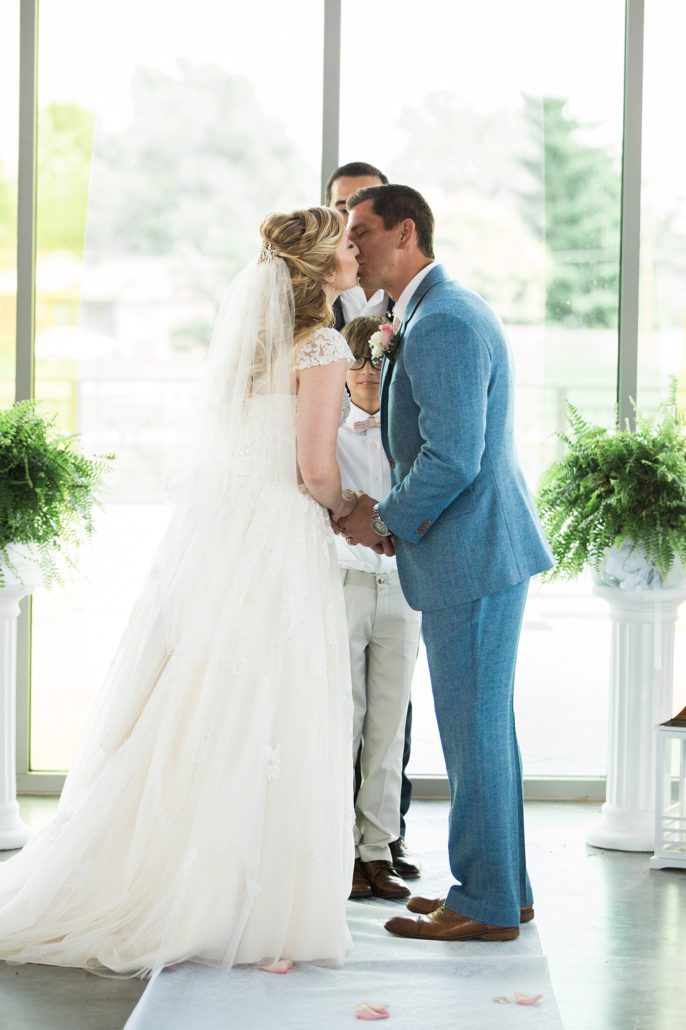 groom and bride first kiss